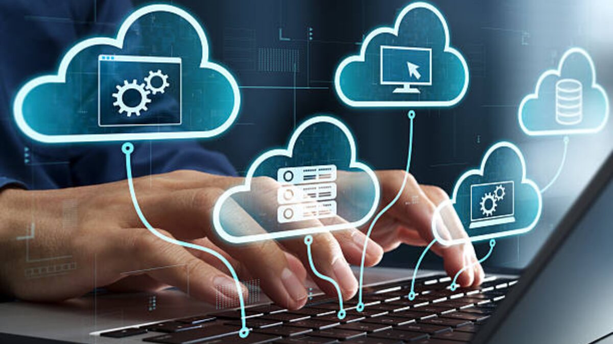 Illustration of cloud computing services with interconnected cloud icons, servers, software, and computer systems displayed above a person typing on a laptop keyboard.
