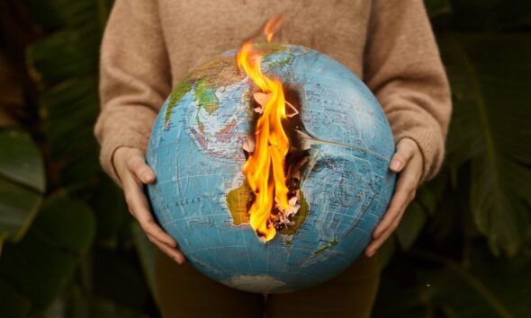 Burning globe held in hands symbolizing global warming and climate crisis