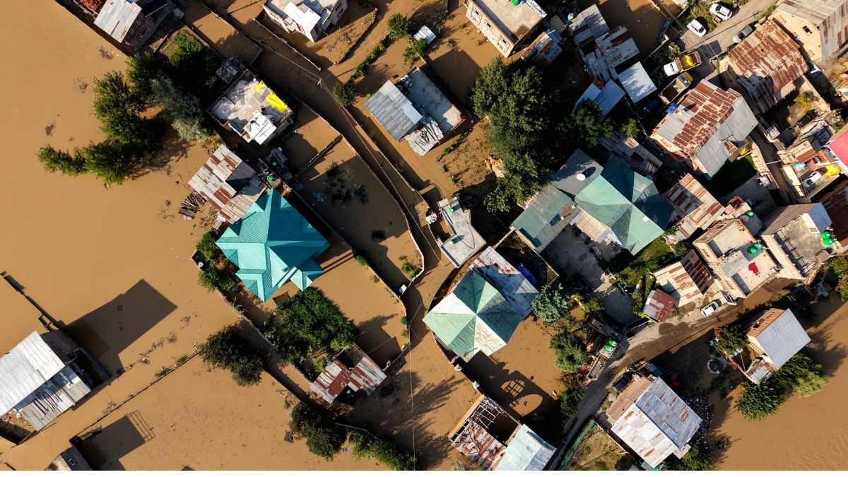 Aerial view of floodwaters inundating homes and roads after heavy rainfall, representing the impact of flash floods in Jammu and Kashmir.