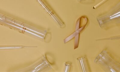 Cancer research laboratory setup with test tubes, syringes and a pink cancer awareness ribbon