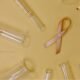 Cancer research laboratory setup with test tubes, syringes and a pink cancer awareness ribbon
