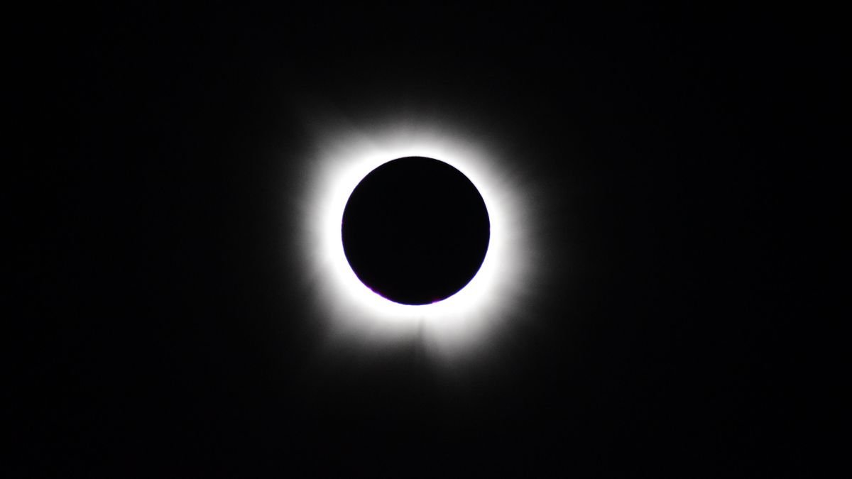 Total solar eclipse with the Moon completely covering the Sun, revealing the glowing solar corona