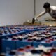 Worker assembling a large array of batteries at an energy storage facility.