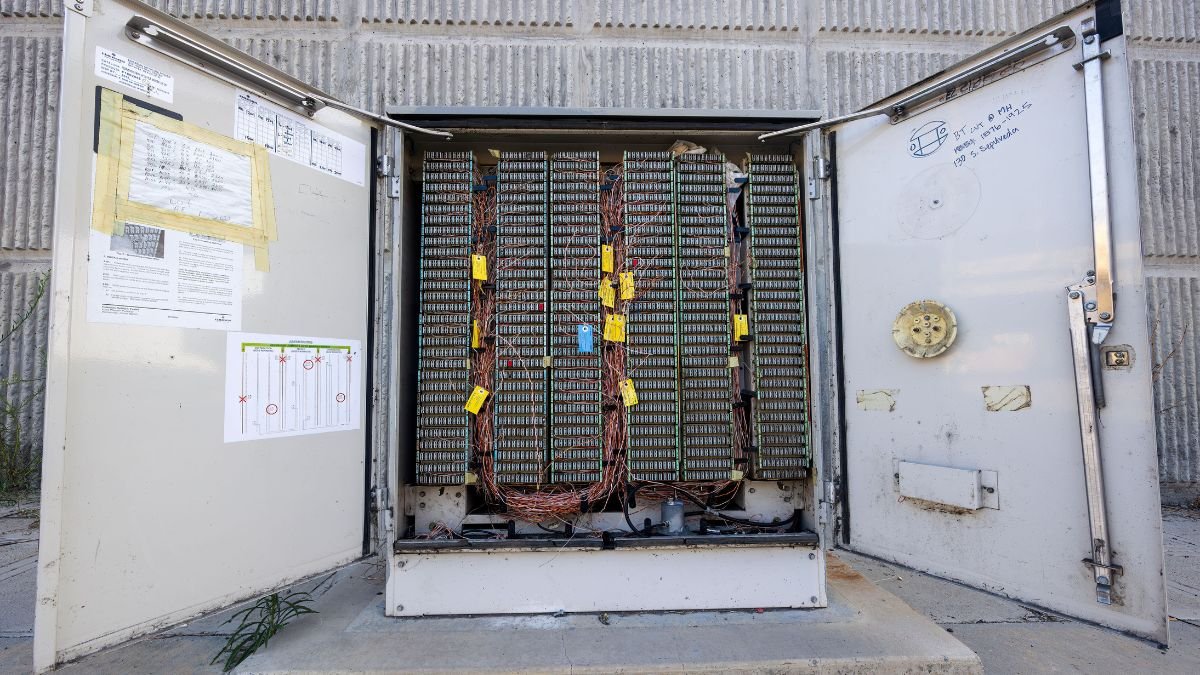 Open battery storage enclosure containing hundreds of connected battery cells and electrical wiring that may help store solar energy.