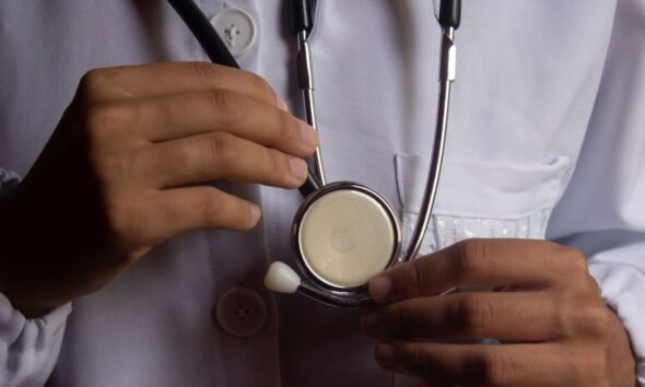 Health worker holding a stethoscope, illustrating risks faced by medical professionals during attacks on health care