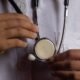 Health worker holding a stethoscope, illustrating risks faced by medical professionals during attacks on health care
