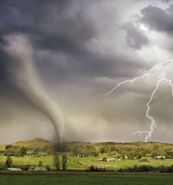 Tornado and lightning over a rural landscape, illustrating the threat of unprecedented extreme events.