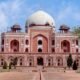 Humayun’s Tomb in Delhi surrounded by trees and gardens under a partly cloudy sky