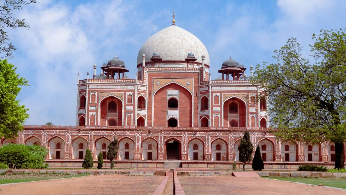 Humayun’s Tomb in Delhi surrounded by trees and gardens under a partly cloudy sky