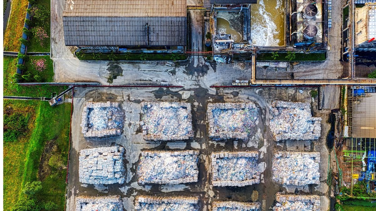 Aerial view of an industrial facility with piles of processed waste, highlighting waste management and CBG production.