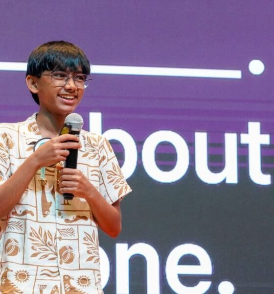 Raul Aju John speaking into a microphone at a technology event