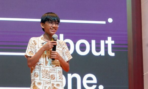 Raul Aju John speaking into a microphone at a technology event