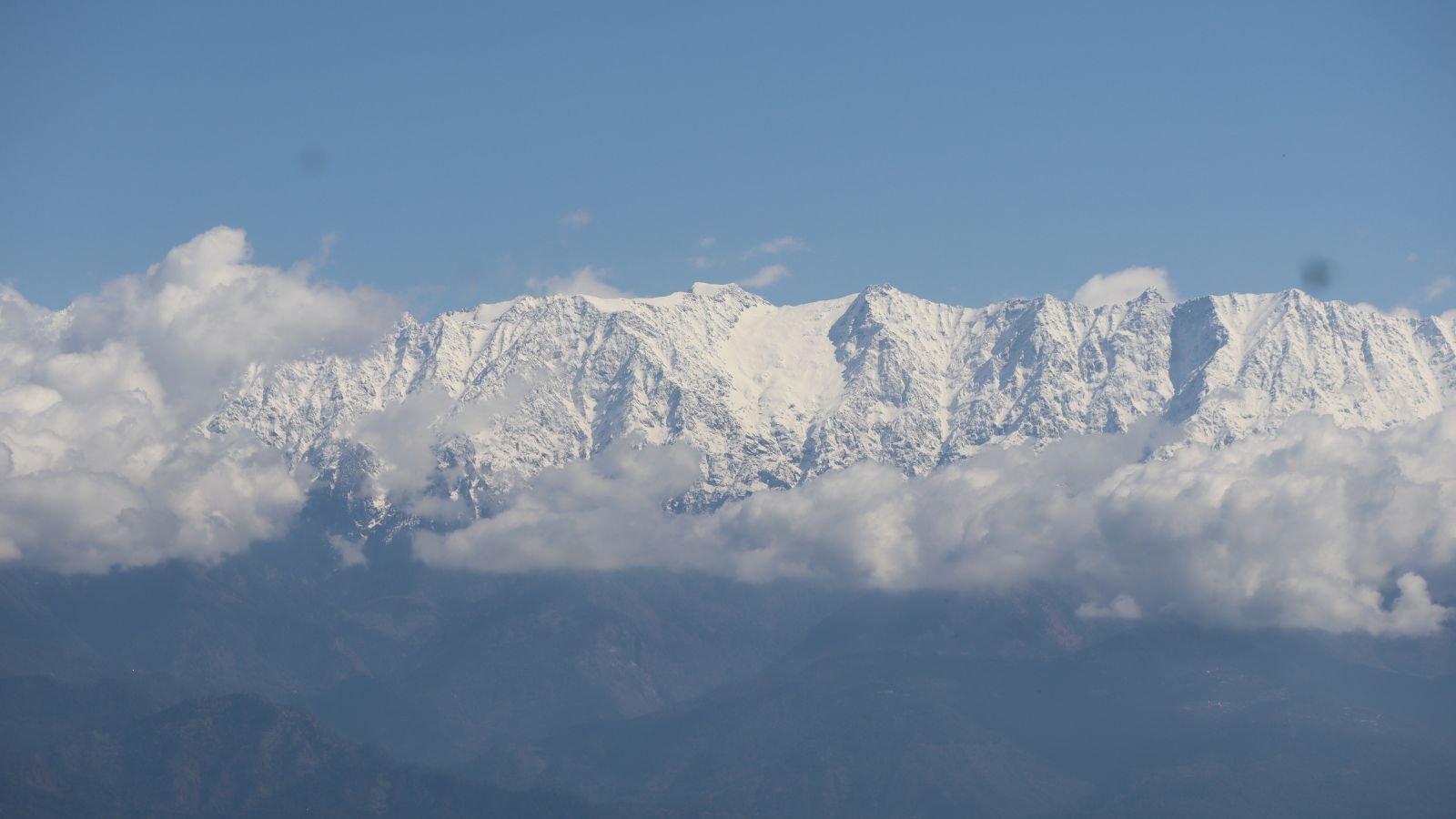 western himalaya warming. Snow-covered Himalayan peaks under a partly cloudy sky