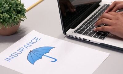 Insurance document with umbrella graphic beside a laptop, illustrating disaster insurance and financial protection against losses.