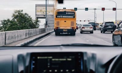 Cars and a city bus travel through busy urban traffic, illustrating connected and autonomous vehicle technology.