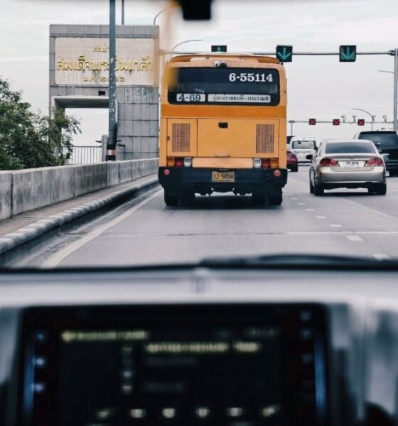 Cars and a city bus travel through busy urban traffic, illustrating connected and autonomous vehicle technology.