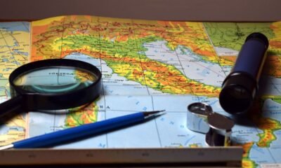 Map with a compass, magnifying glass and navigation tools, illustrating the representation of geographical size on world maps.