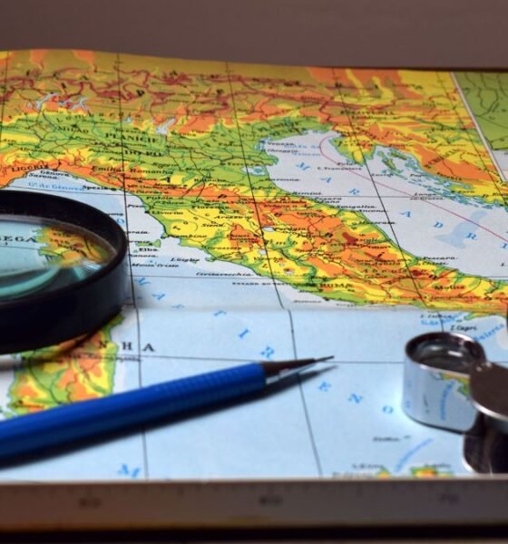 Map with a compass, magnifying glass and navigation tools, illustrating the representation of geographical size on world maps.