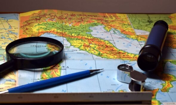 Map with a compass, magnifying glass and navigation tools, illustrating the representation of geographical size on world maps.