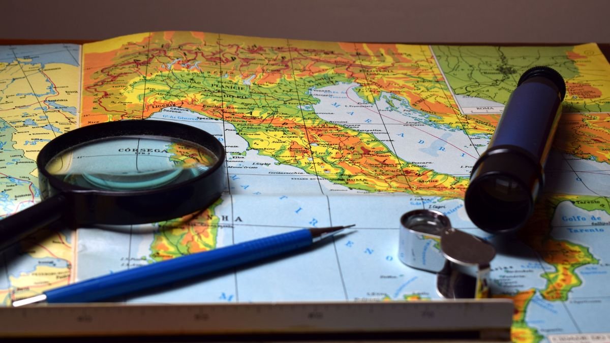 Map with a compass, magnifying glass and navigation tools, illustrating the representation of geographical size on world maps.