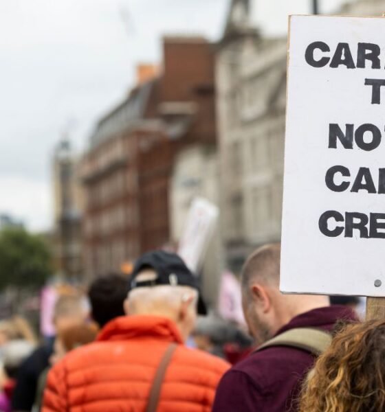 Protester holds a “Carbon Tax Not Carbon Credits” sign as carbon pricing gains importance in global trade