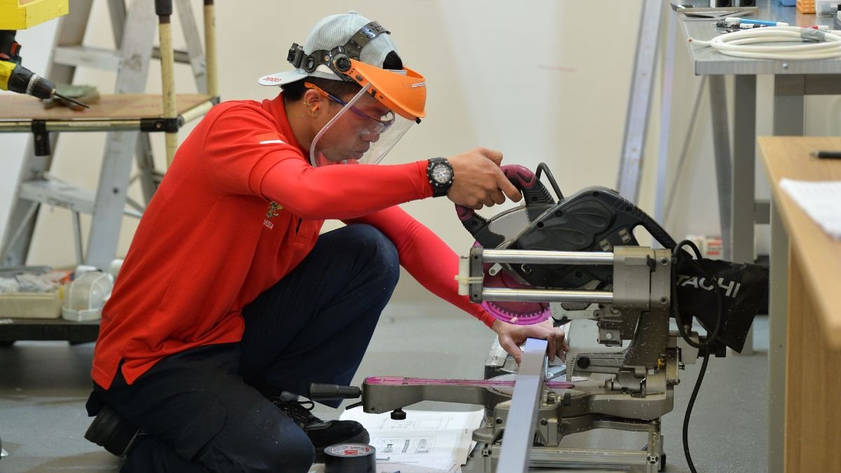Skilled worker operating industrial machinery during technical training