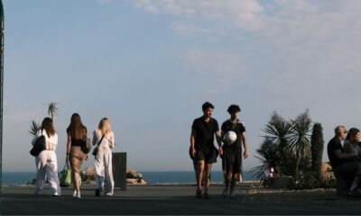 People walking and sitting in a European coastal city as rising temperatures increase heat exposure and heat-related health risks across Europe.