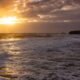 Ocean waves under a dramatic sunset as global ocean temperatures reach record highs