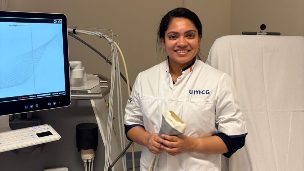 Photoacoustic imaging: Anjali Thomas holding an imaging probe beside a medical imaging system
