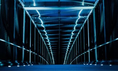 Rows of computer servers inside a large, illuminated data centre