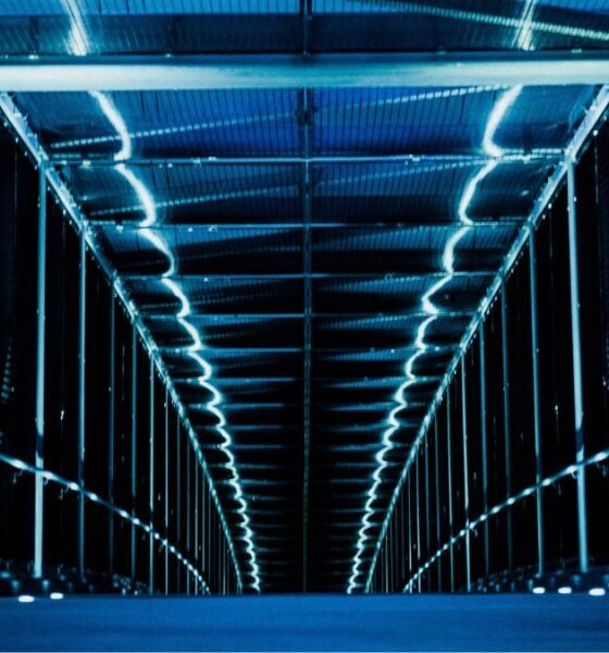 Rows of computer servers inside a large, illuminated data centre