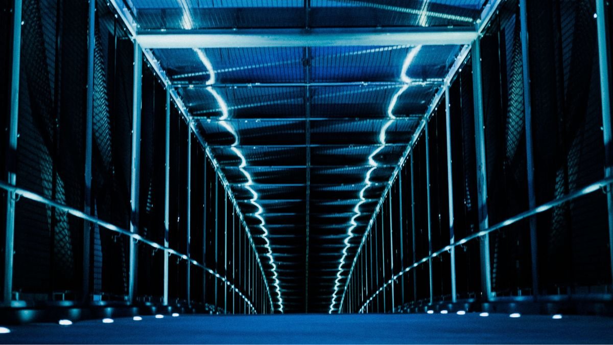 Rows of computer servers inside a large, illuminated data centre