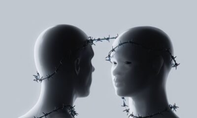 Conceptual image of two humanoid figures facing each other with barbed wire around their heads and necks, representing AI risks and safety constraints.