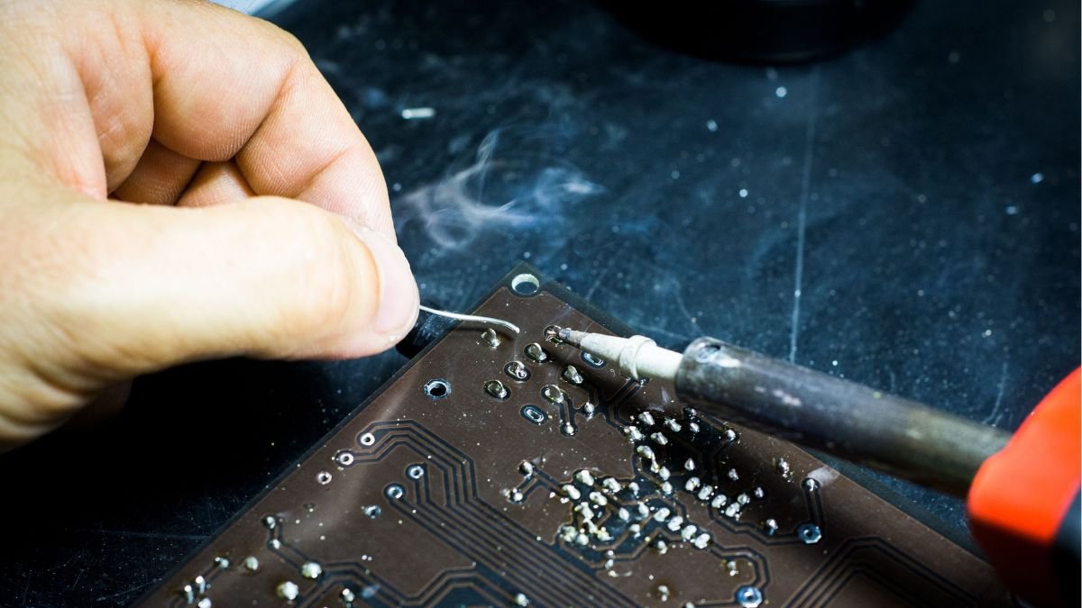 Technician soldering a printed circuit board, illustrating hands-on electronics manufacturing and semiconductor industry skills