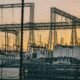 Electrical substation and high-voltage transmission infrastructure against a sunset sky.