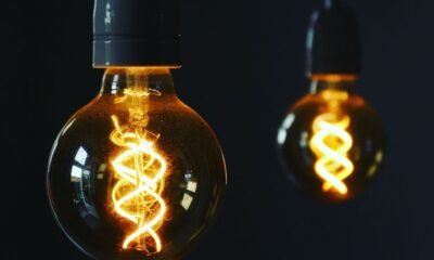 Two glowing vintage light bulbs illuminating a dark background, symbolising access to electricity.