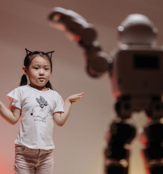 Girl standing beside a humanoid robot, illustrating the gender gap in artificial intelligence and who shapes the technology
