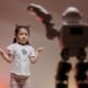 Girl standing beside a humanoid robot, illustrating the gender gap in artificial intelligence and who shapes the technology
