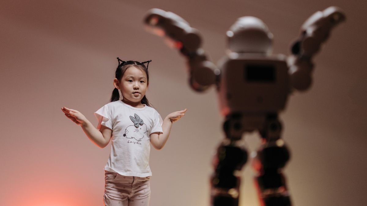 Girl standing beside a humanoid robot, illustrating the gender gap in artificial intelligence and who shapes the technology