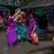 Women and children wade through floodwater around their homes, illustrating the human impact of flooding in the context of Nepal’s climate disaster recovery needs.