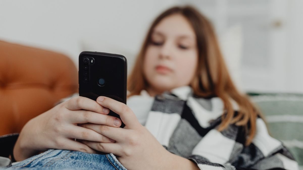 Teenager using a smartphone as Greece moves to ban social media access for children under 15.