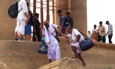 Older people receiving assistance while navigating uneven steps at a public site