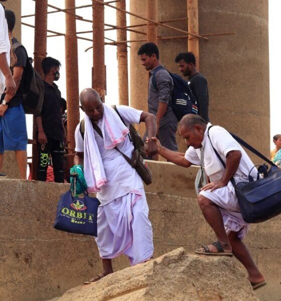 Older people receiving assistance while navigating uneven steps at a public site
