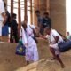 Older people receiving assistance while navigating uneven steps at a public site