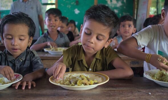 School meal workers prepare food for children in a school feeding programme