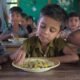 School meal workers prepare food for children in a school feeding programme