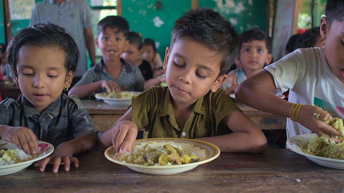 School meal workers prepare food for children in a school feeding programme