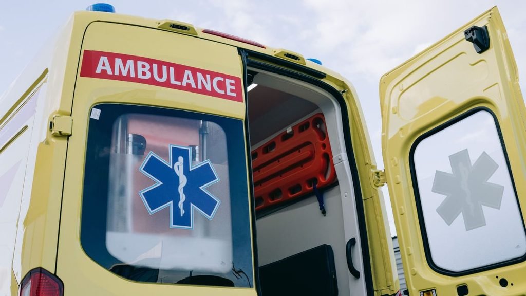 Hospital: Yellow ambulance with its rear doors open, showing a stretcher inside.