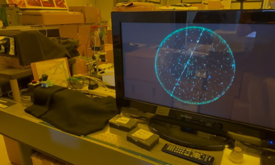 Computer monitor displaying cosmic-ray particle tracks in a physics laboratory.