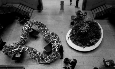 Folded aluminium geometric structure displayed in a public library atrium, demonstrating an origami-inspired architectural design.